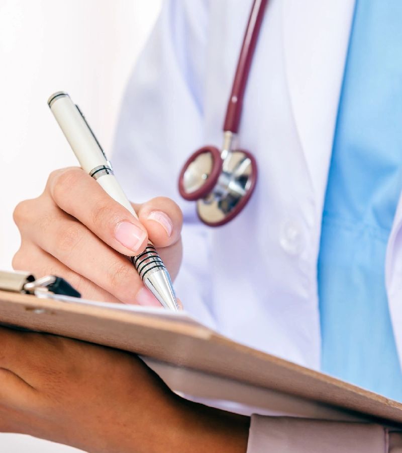 Doctor writing on clipboard